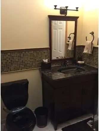 Dark granite vanity top with an undermount sink and mosaic tile band