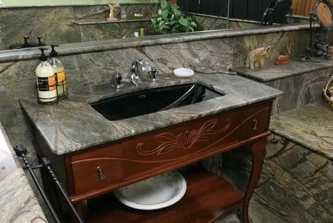 Green and brown granite vanity top on a carved wood cabinet