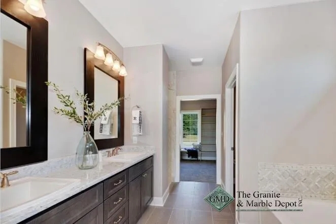 Grey quartz double vanity on dark cabinets with a framed mirror