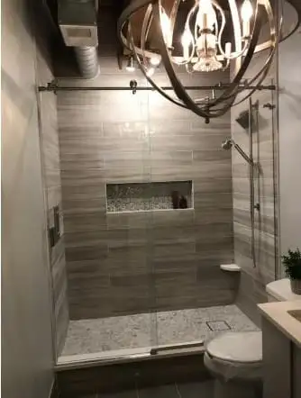 Grey tiled walk-in shower with a recessed niche