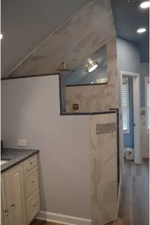 Marble-tiled bathroom walls trimmed with dark stone