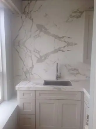 White marble slab wall behind a floating stone sink