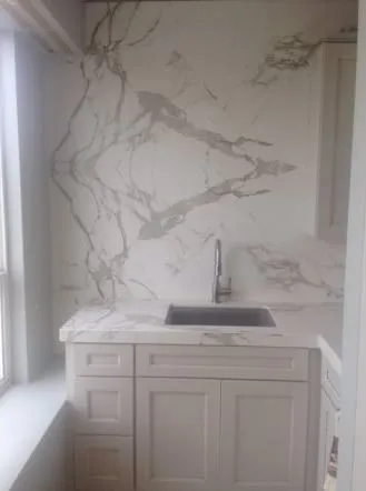 White marble slab wall behind a floating stone sink