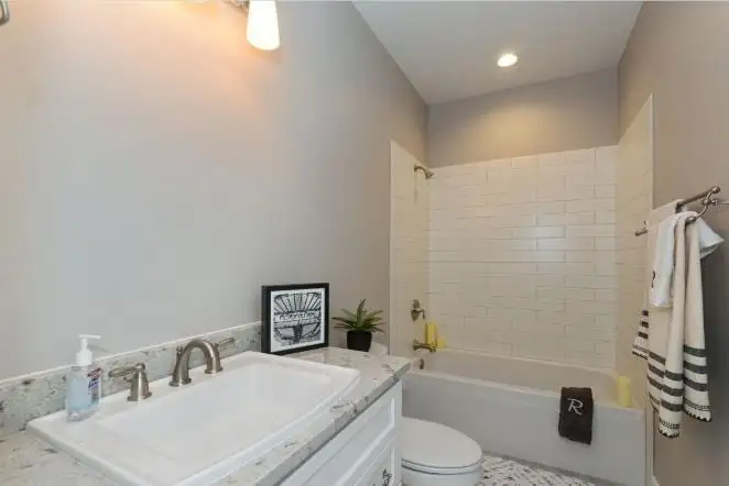 White tub with a tiled surround in a bright bathroom