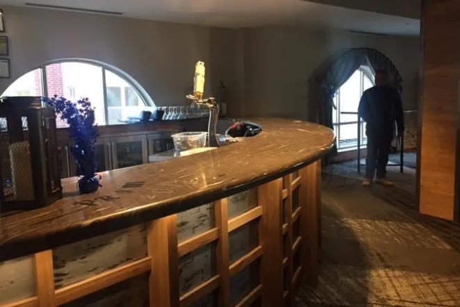 Curved bar with a stone top beneath an arched window