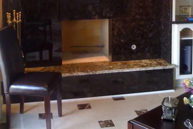 Brown granite fireplace wall with a built-in stone bench