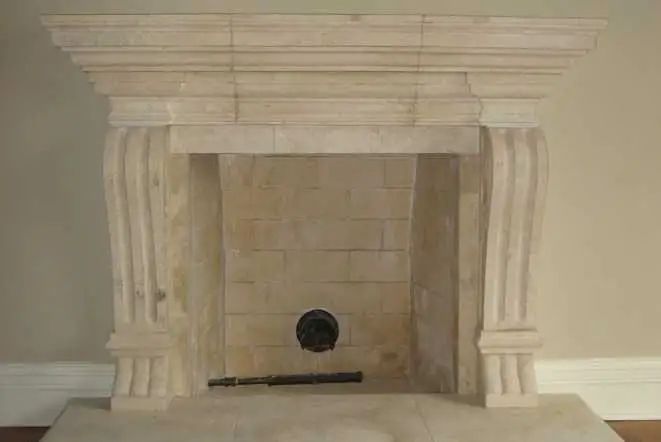 Travertine fireplace mantel with column legs and a stone hearth