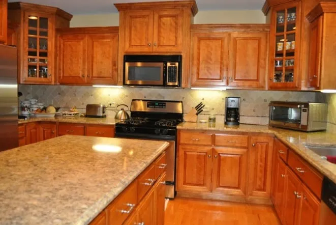 Beige granite countertops with tile backsplash in an oak-cabinet kitchen