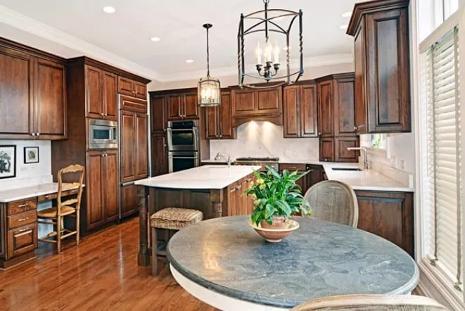 Round blue-grey granite table top beside dark cabinetry
