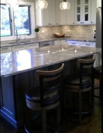 Dark island with grey granite top and leather counter stools