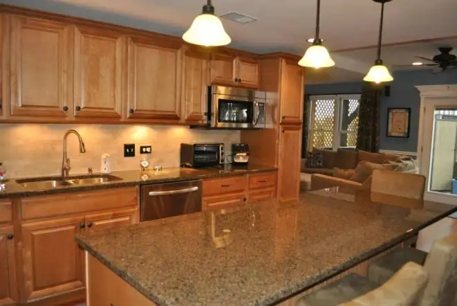Maple cabinets with granite countertops and an undermount sink below a window