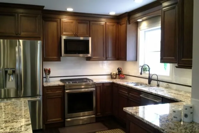 Dark cabinets with granite countertops and a stainless range and microwave