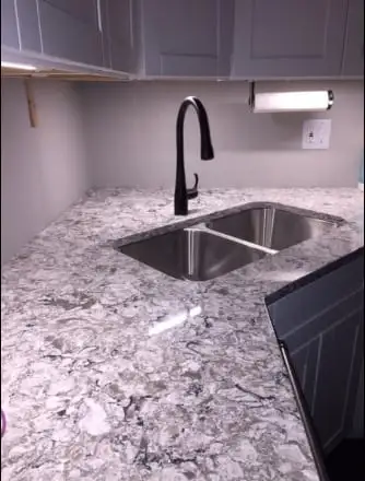 Grey and white granite countertop with a corner undermount sink