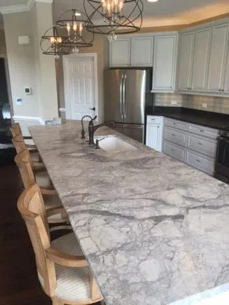 Long grey and white quartzite island with counter seating