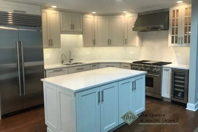Marble slab backsplash and blue-grey island beside a professional range