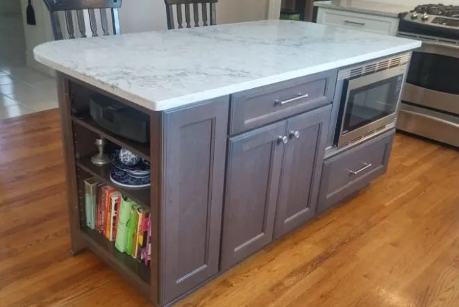 Grey island with a marble-look top and open shelving on the end