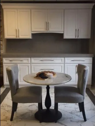 Round marble table top in a white cabinet kitchen nook
