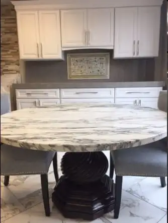 Round white granite table top with grey veining on a pedestal base