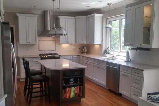 Compact white kitchen island with counter stools and a stainless hood