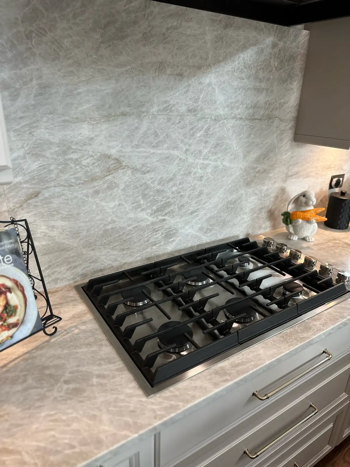 Close view of Taj Mahal quartzite counters meeting the full-height slab backsplash