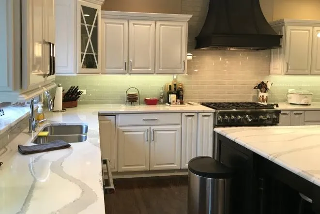 Veined white quartz countertops with bar seating in a white kitchen