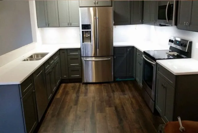 White stone counters over deep green base cabinets with white uppers